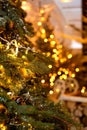 Natural Christmas tree close-up with unfocused garland lights. Christmas background with golden bokeh. Royalty Free Stock Photo