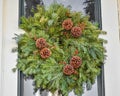 Natural Christmas Wreath With Pinecones on Gray Door