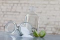 Natural cleaning products, including sodium bicarbonate, invert jar, baking soda, lemon, vinegar,on grey table on old