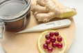 Natural cold remedies on A round WOODEN TRAY, ginger, cranberries, thermometer, jar of honey, banner