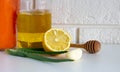 Natural cold remedies on a white table on a brick background. Garlic, honey, lemon, aloe folk remedies for autumn colds