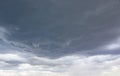 Natural color dramatic dark blue cloudy sky with wavy rippling clouds aligned above horizon, taken with wide angle 35 mm lens Royalty Free Stock Photo