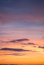 Natural color dramatic dawn or dusk sky with painterly yellow, pink and blue clouds with horizon, taken with telephoto 135 mm