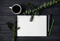 Sketchbook and pencils on black wooden table, decorated with green eucalyptus branches. Flat lay, top view Royalty Free Stock Photo
