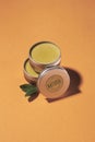 Natural cosmetic. Lip balm in a metal jar on a orange background