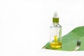 Natural cosmetic product in a glass bottle. organic extract, serum, essential massage oil for skin care on a green leaf