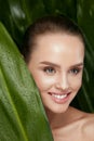 Natural Cosmetics. Beautiful Woman Face With Green Plant