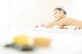Natural cosmetics and concept. Close up of salt with massage oil and bath towel on Spa bed. Bottle of massage oil, hot stone spa Royalty Free Stock Photo