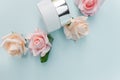 Natural cosmetics products  advertising composition on blue  pastel  background with roses  flowers  . Royalty Free Stock Photo