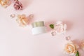 Natural cosmetics products series advertising composition on pink pastel background with roses flowers . Moisturizing face cream j Royalty Free Stock Photo