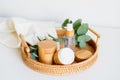 Natural cosmetics set in eco-friendly packaging in rattan tray with eucalyptus and towel. SPA, bath beauty products