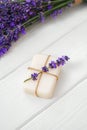 Natural cube of lavender soap on white wooden background