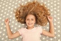 Natural curls treat and care. Girl child with long curly hair lay on bed top view. Child perfect curly hairstyle looks