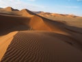 Natural curved ridge line and wind blow pattern of rusty red sand dune with shade and shadow on vast desert landscape horizon Royalty Free Stock Photo