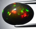natural dark multicolor rainbow opal gem on the background Royalty Free Stock Photo