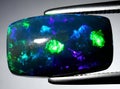 natural dark rainbow opal gem on the background Royalty Free Stock Photo