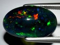 natural dark rainbow opal gem on the background Royalty Free Stock Photo