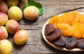 Natural dried apricots in bamboo bowl with Fresh whole Ripe apricot on wooden rustic backdrop Royalty Free Stock Photo