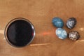 Natural dye easter eggs on wooden table. Modern grey, dark and stone marble easter eggs painted with carcade tea, glass jar with Royalty Free Stock Photo