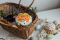 Natural dyed easter eggs, easter bread, ham, beets, butter, cheese in wicker basket decorated with green buxus on rustic wooden Royalty Free Stock Photo