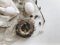 Natural easter eggs, feathers, pussy willow branches, nest on cloth on rustic white table. Flat lay