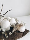 Natural easter eggs, feathers, pussy willow on cloth on rustic table. Stylish rural still life