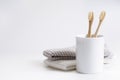 Natural eco friendly toothbrush with wooden bamboo handle in a white cup