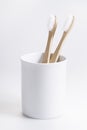 Natural eco friendly toothbrush with wooden bamboo handle in a white cup