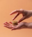 Natural eco lip balm with female hands over beige Royalty Free Stock Photo