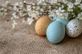 Natural eggs arranged on a burlap cloth with delicate white flowers in a sunlit setting, creating a rustic and Royalty Free Stock Photo