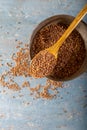 Natural Einkorn bulgur in wooden spoon on wooden background. Top view. Siyez.