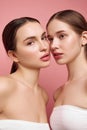 Natural elegance. Girls find true beauty in unity. Portrait of two pretty ladies with bare shoulders posing against pink