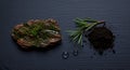 Natural elements of rosemary, moss, and soil on a dark textured surface mockup Royalty Free Stock Photo