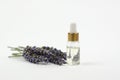 Natural essential oil and lavender flowers on a white background. Lavender essential oil in a transparent bottle with a dropper Royalty Free Stock Photo
