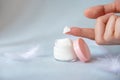 Natural face cream in a cosmetic jar. Female hand tries to smear cream Royalty Free Stock Photo