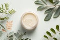 Natural face cream in petri dish on a white table and plant branches, copy space