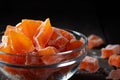 Natural farm homemade candied pumpkin fruits sprinkled with powdered sugar in a glass bowl on a wooden table Royalty Free Stock Photo