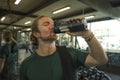 Natural fitness lifestyle portrait of young happy and attractive man drinking bottle of water training at gym smiling cheerful Royalty Free Stock Photo