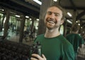 Natural fitness lifestyle portrait of young happy and attractive man drinking bottle of water training at gym smiling cheerful Royalty Free Stock Photo