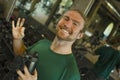 Natural fitness lifestyle portrait of young happy and attractive man holding bottle of water training at gym smiling cheerful Royalty Free Stock Photo