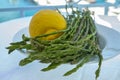 Natural food from forest and mountains in Greece green wild asparagus and lemon on balcony with sea view Royalty Free Stock Photo