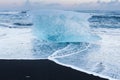 Natural freezing iceberg over black sand beach, Iceland