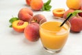 Natural freshly made peach juice on white table, closeup