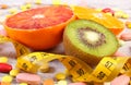 Natural fruits, centimeter and medical pills, slimming, choice between healthy nutrition and medical supplements Royalty Free Stock Photo