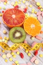 Natural fruits, centimeter and medical pills, slimming, choice between healthy nutrition and medical supplements Royalty Free Stock Photo