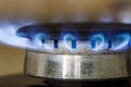 Natural gas blue flames burns on the kitchen stove hob, close up