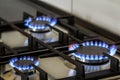 Natural gas burning on kitchen gas stove in the dark. Panel from steel with a gas ring burner on a black background, close-up shoo Royalty Free Stock Photo