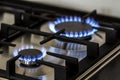 Natural gas burning on kitchen gas stove in the dark. Panel from steel with a gas ring burner on a black background, close-up shoo Royalty Free Stock Photo