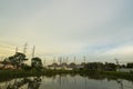 Natural gas electric power plant with smokestack and many pole in chonburi thailand with water reflection and beautiful sky near Royalty Free Stock Photo