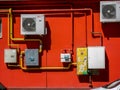 Natural   gas meters , pipes , air conditioning systems on vibrant red wall. Royalty Free Stock Photo